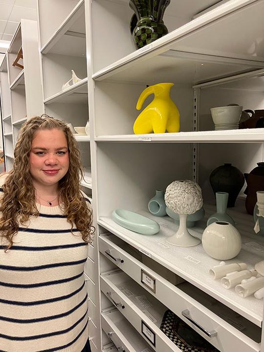 woman standing by some ceramic pots